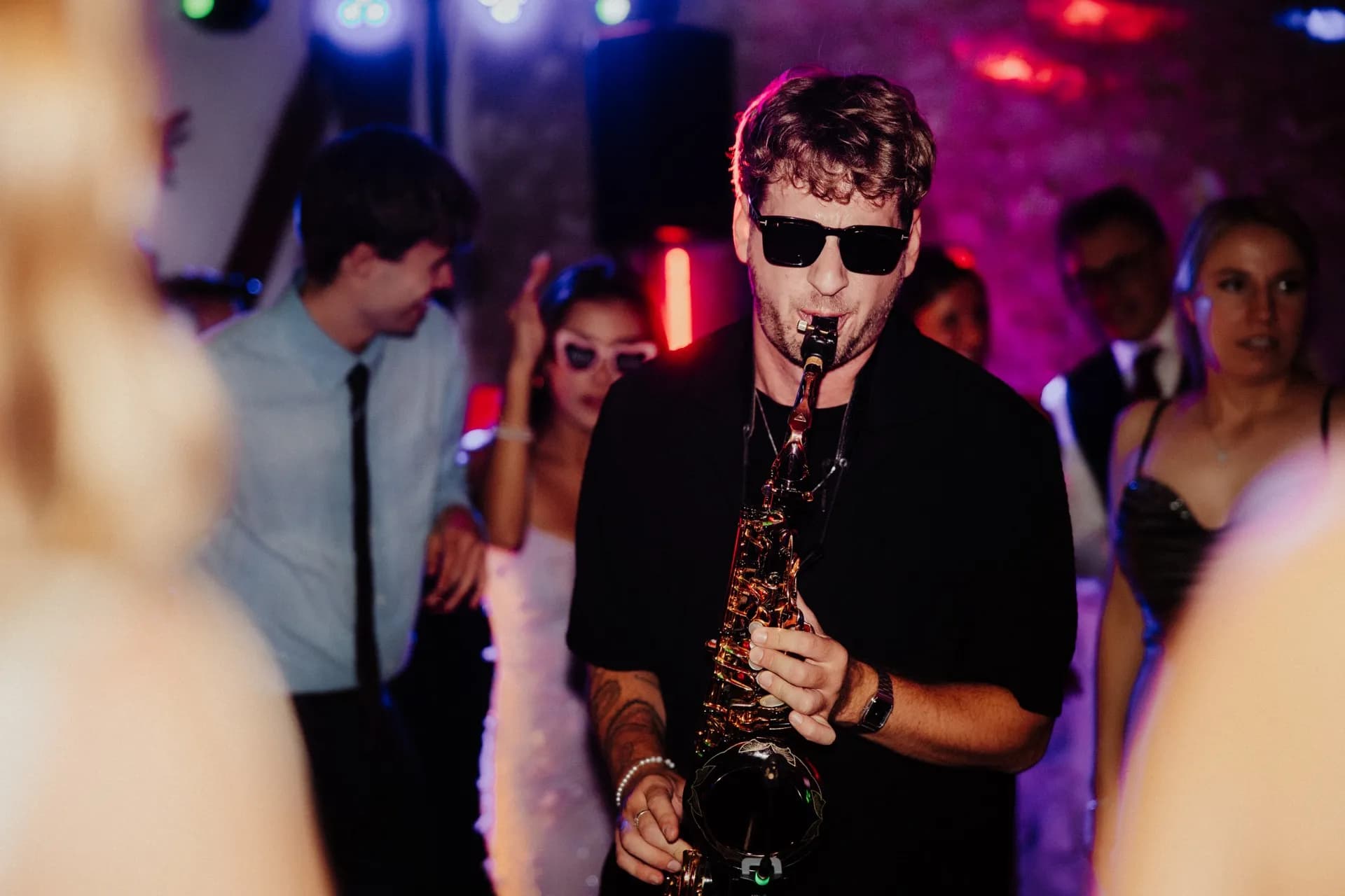 Pascal performing with saxophone among the guests