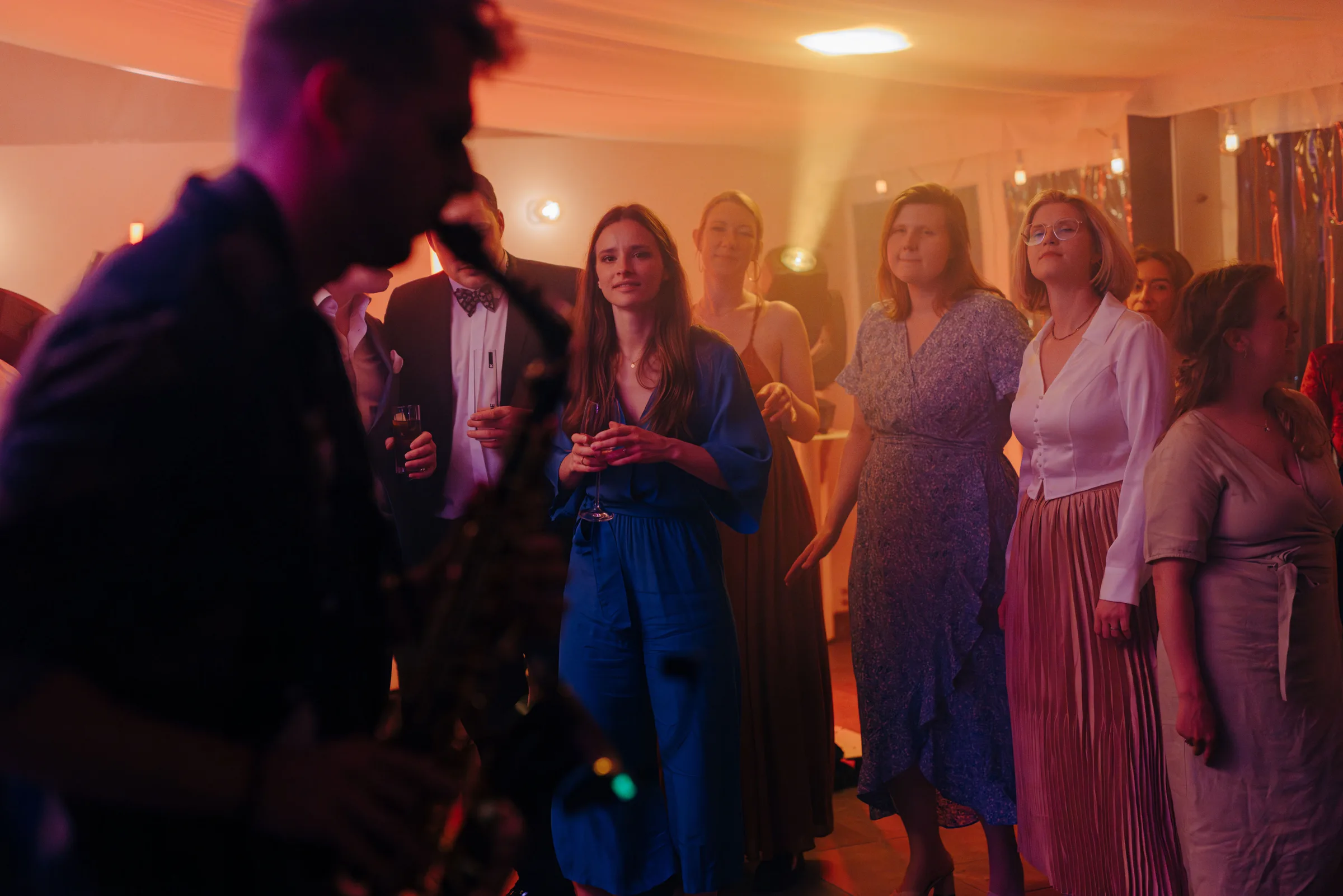 Hochzeitsgäste schauen begeistert der Saxophon-Performance zu