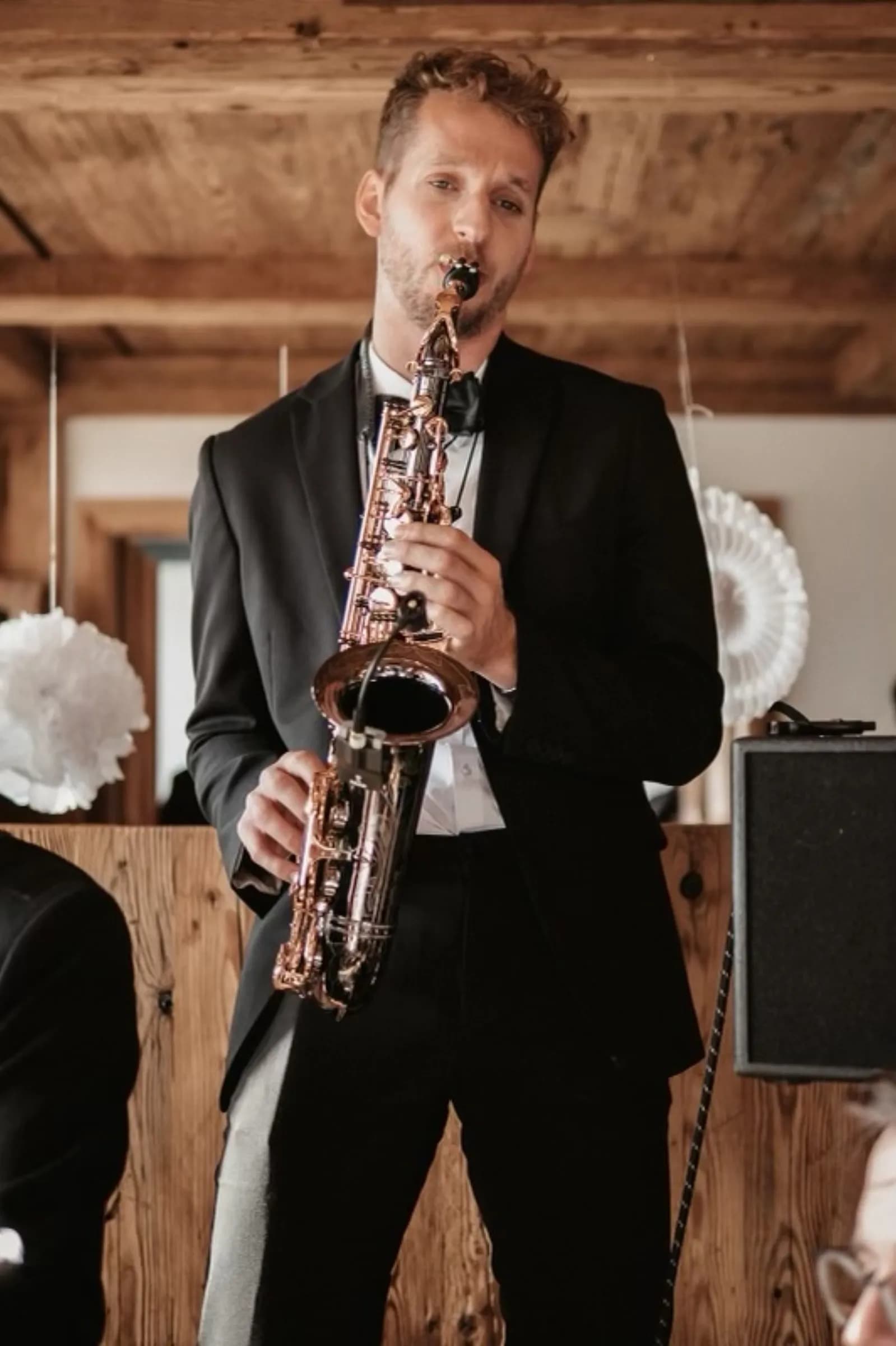 Pascal playing saxophone at a rustic wedding venue